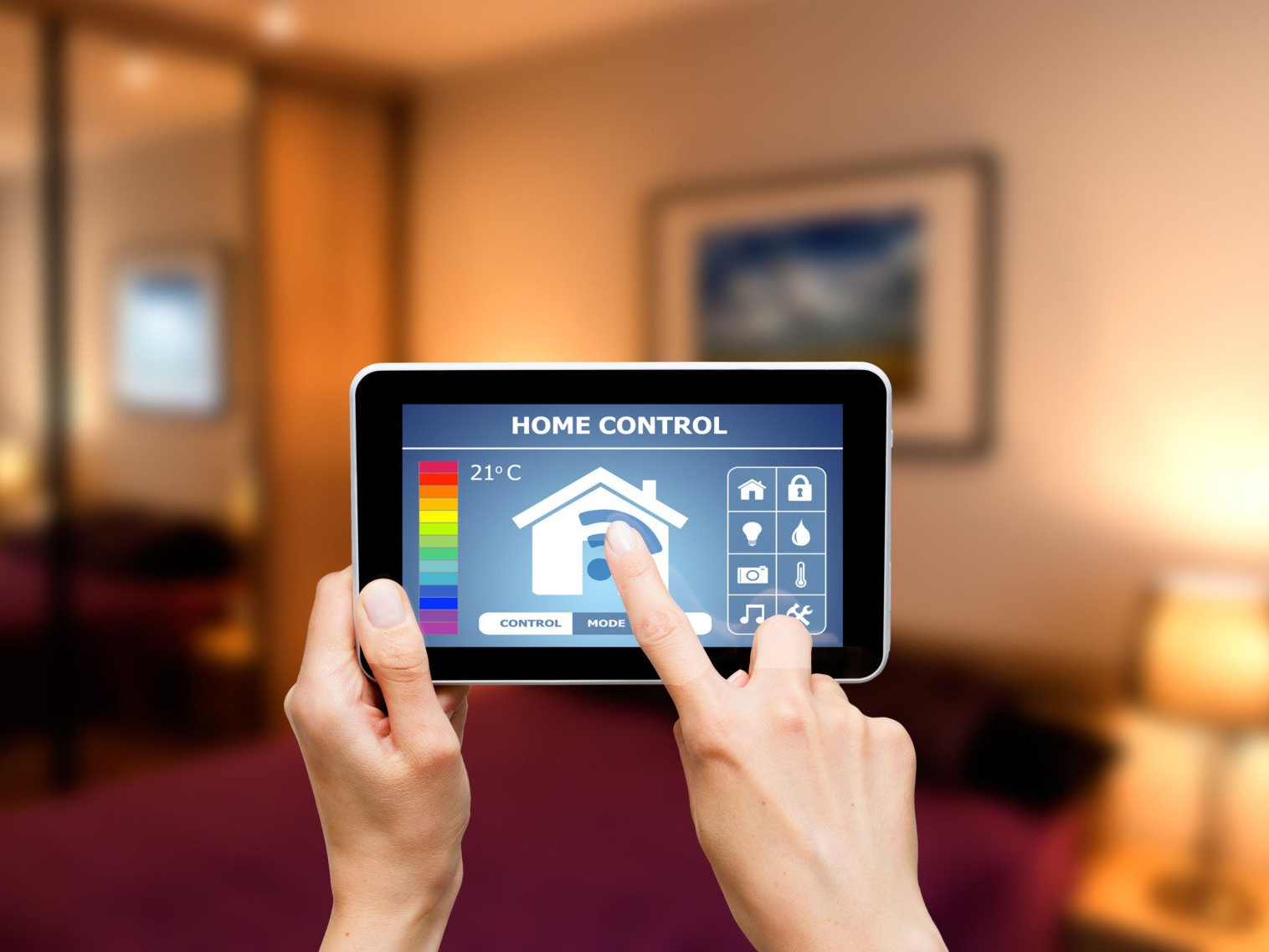 A person is holding a tablet with a home control screen on it.