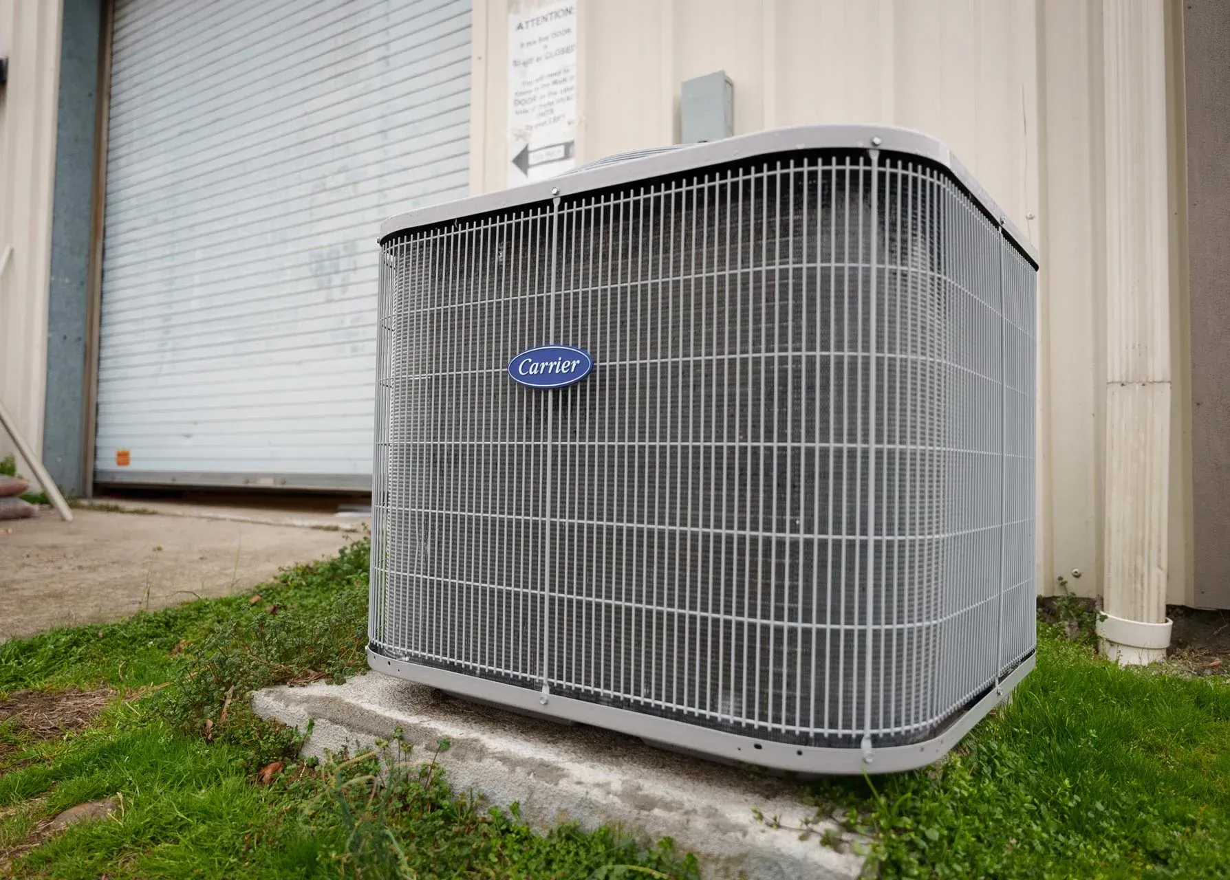 A large air conditioner is sitting on the side of a building.