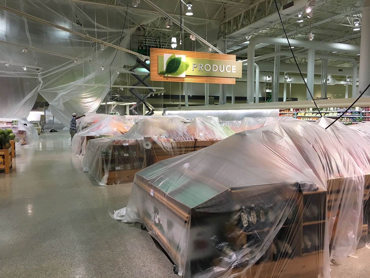 A produce section of a grocery store is covered in plastic