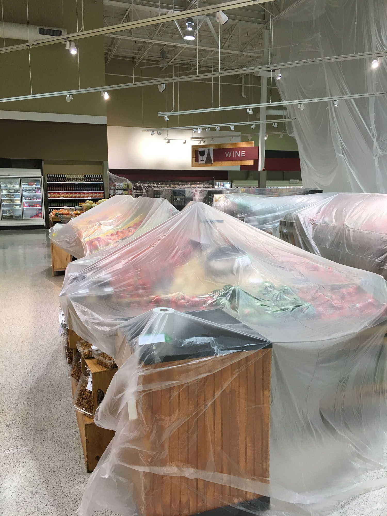 The inside of a grocery store is covered in plastic.