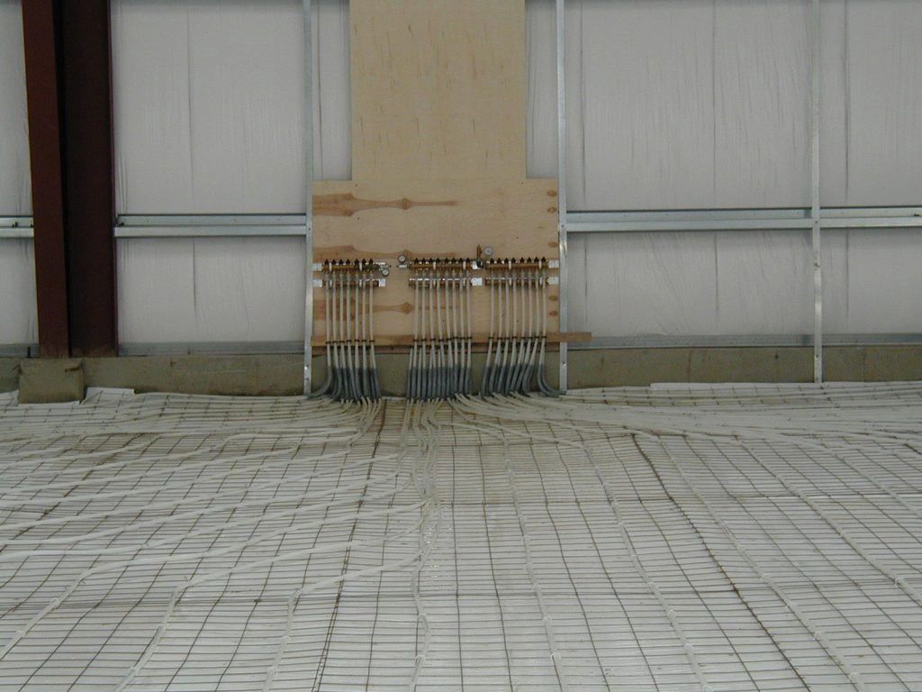 A concrete floor with a wooden wall in the background