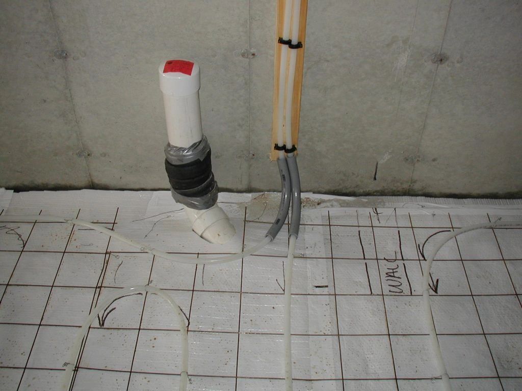 A white pipe with a red cap is sitting on a white tile floor