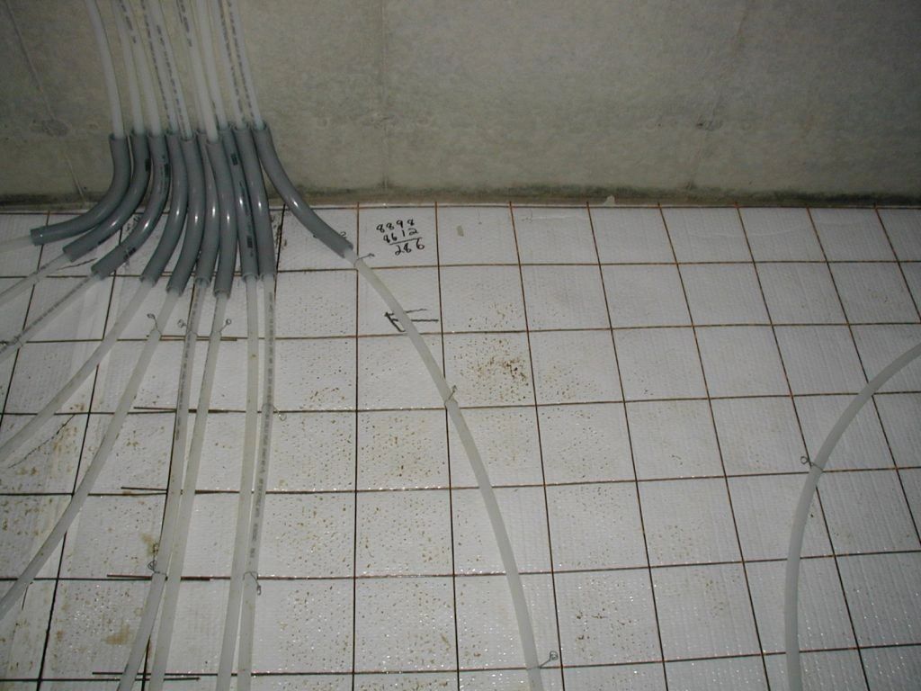 A bunch of wires are laying on a tiled floor