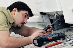 man repairing refrigerator