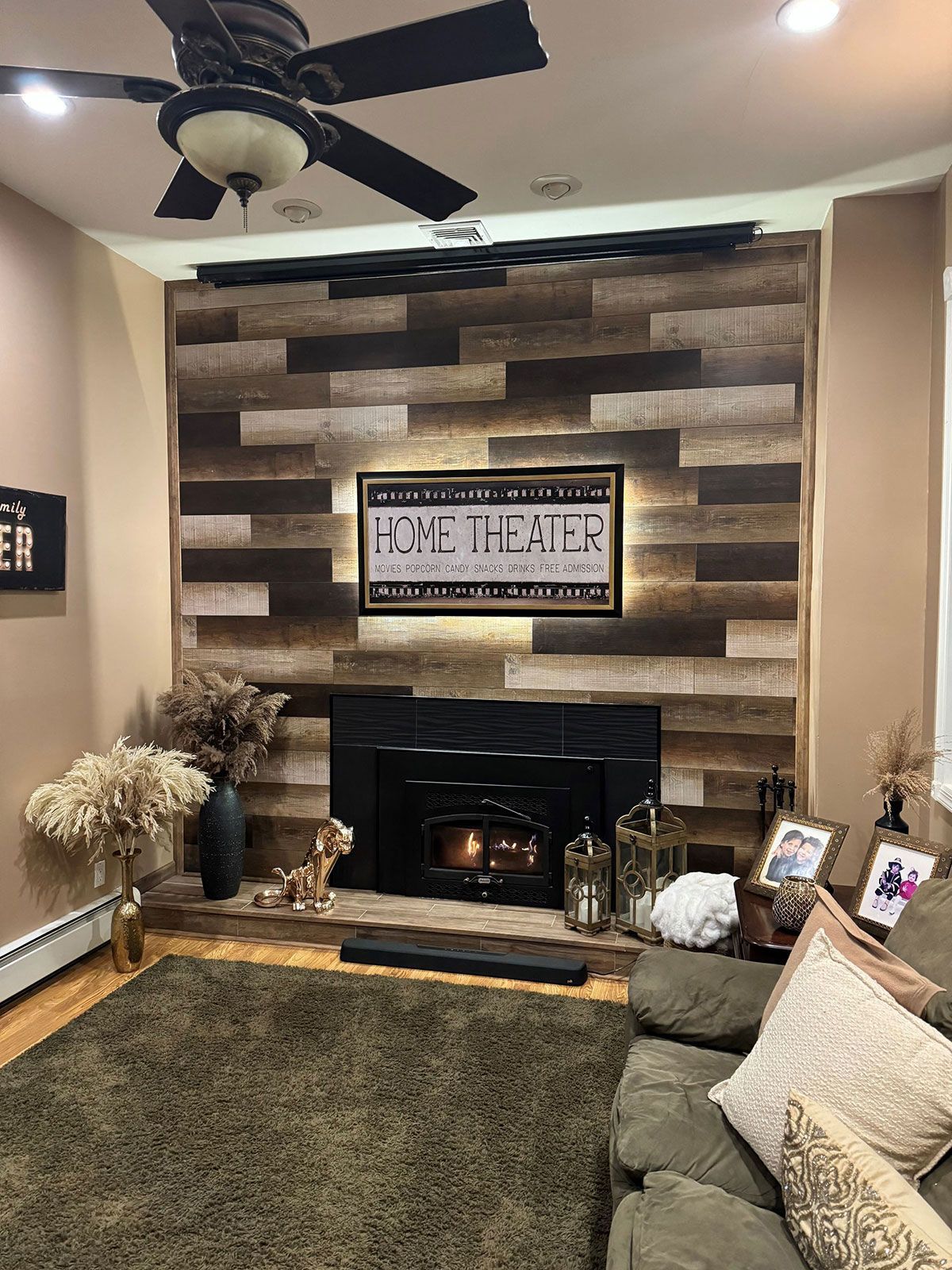 Theater room with a fireplace and a ceiling fan