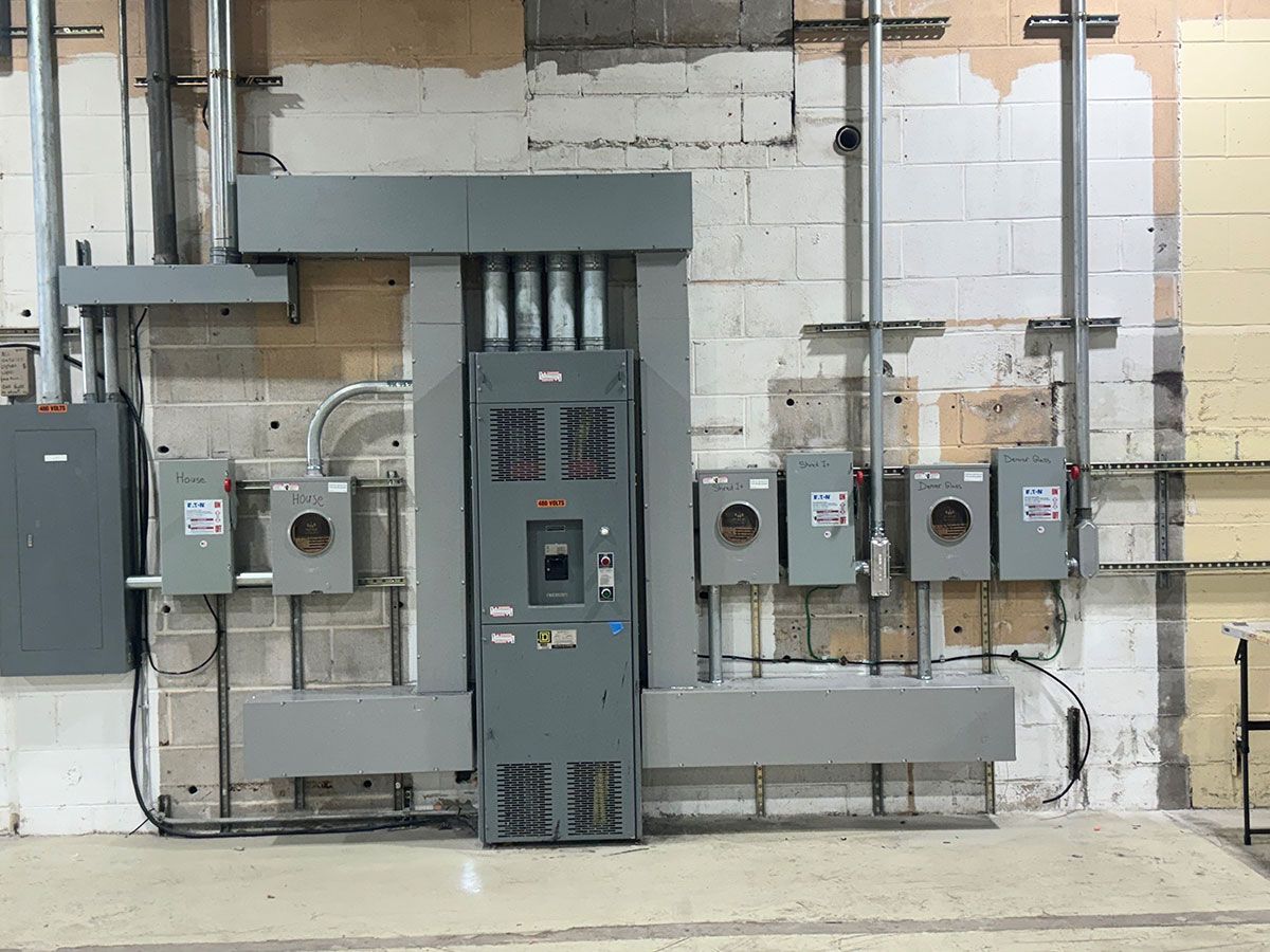 There are a lot of electrical panels on the wall of a building