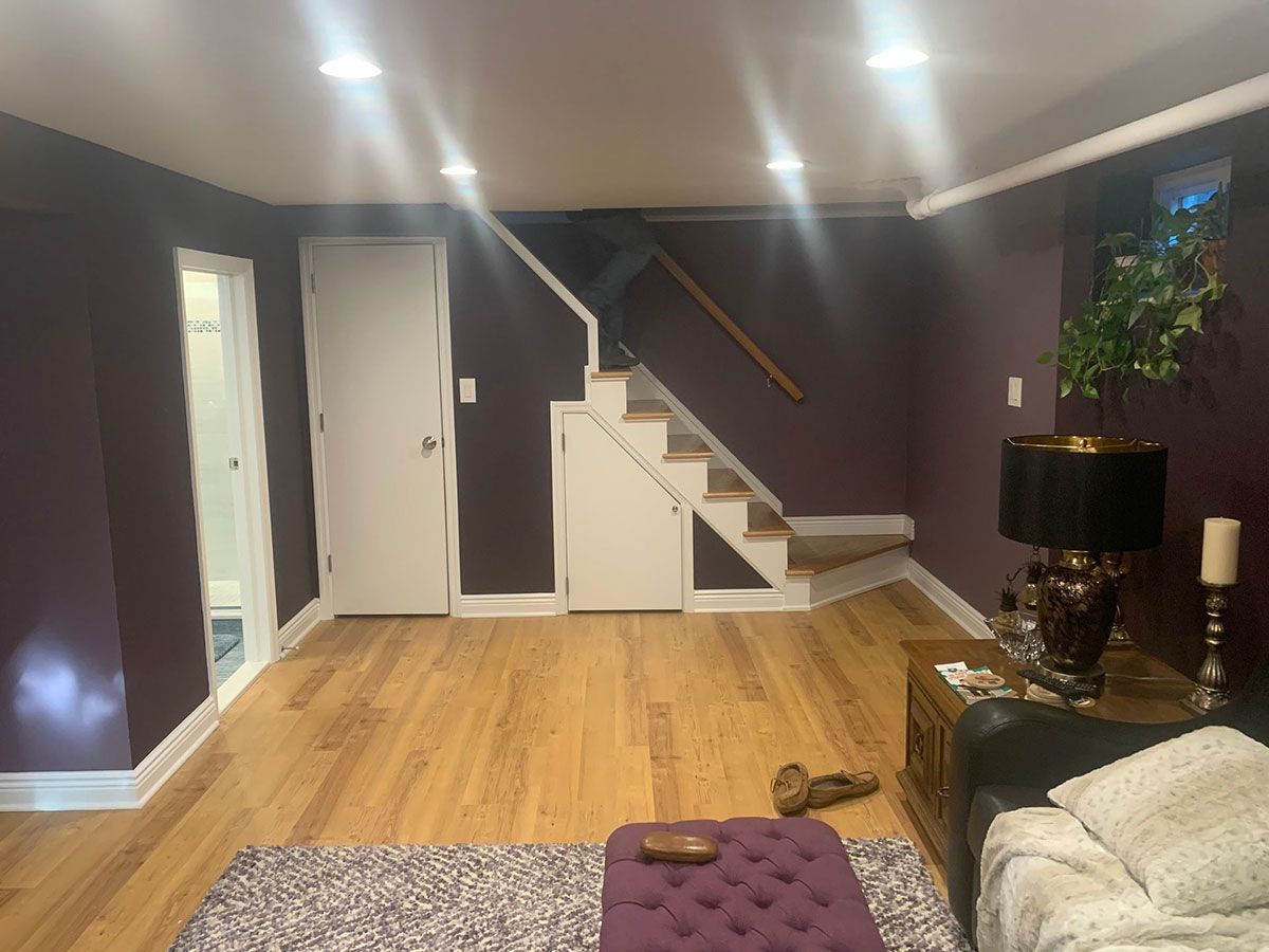 A living room with purple walls and wooden floors