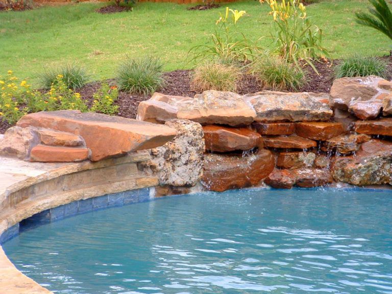 A swimming pool with a waterfall in the middle of it