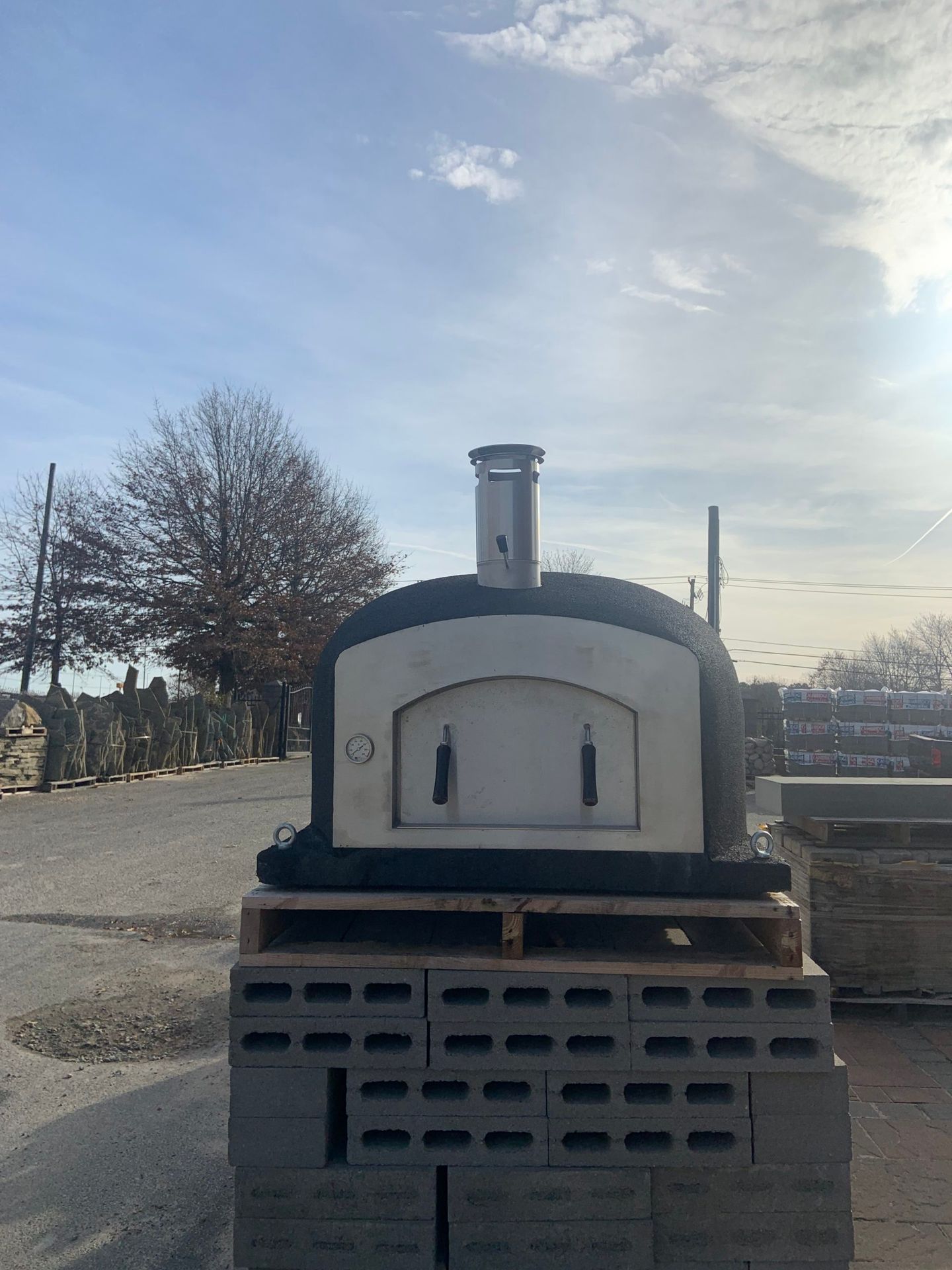 A large oven is sitting on top of a pile of bricks.