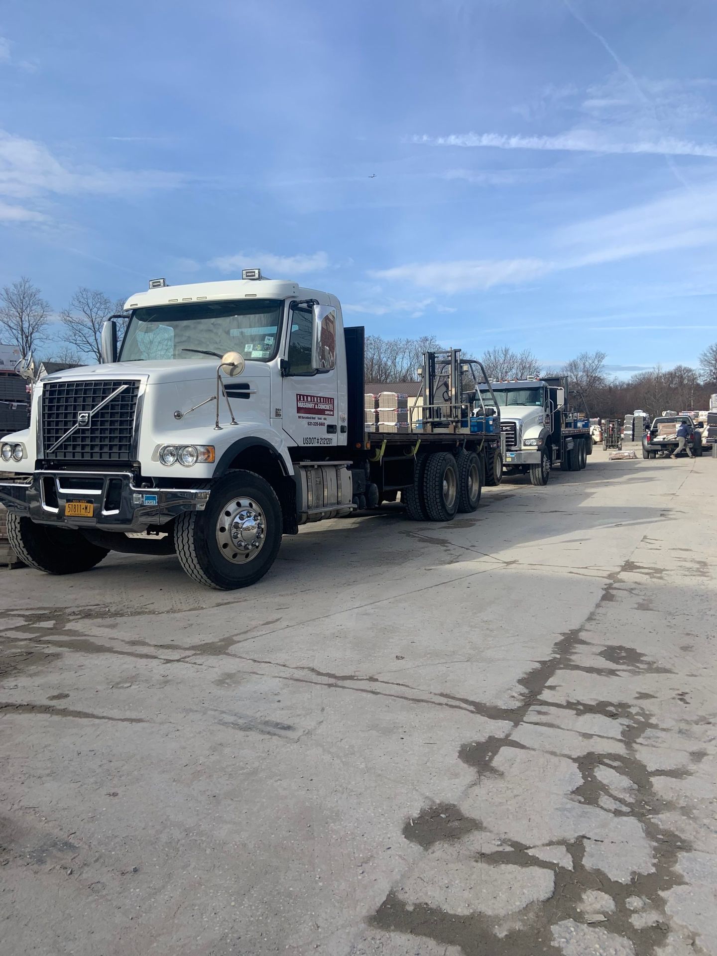 A row of trucks are parked in a parking lot