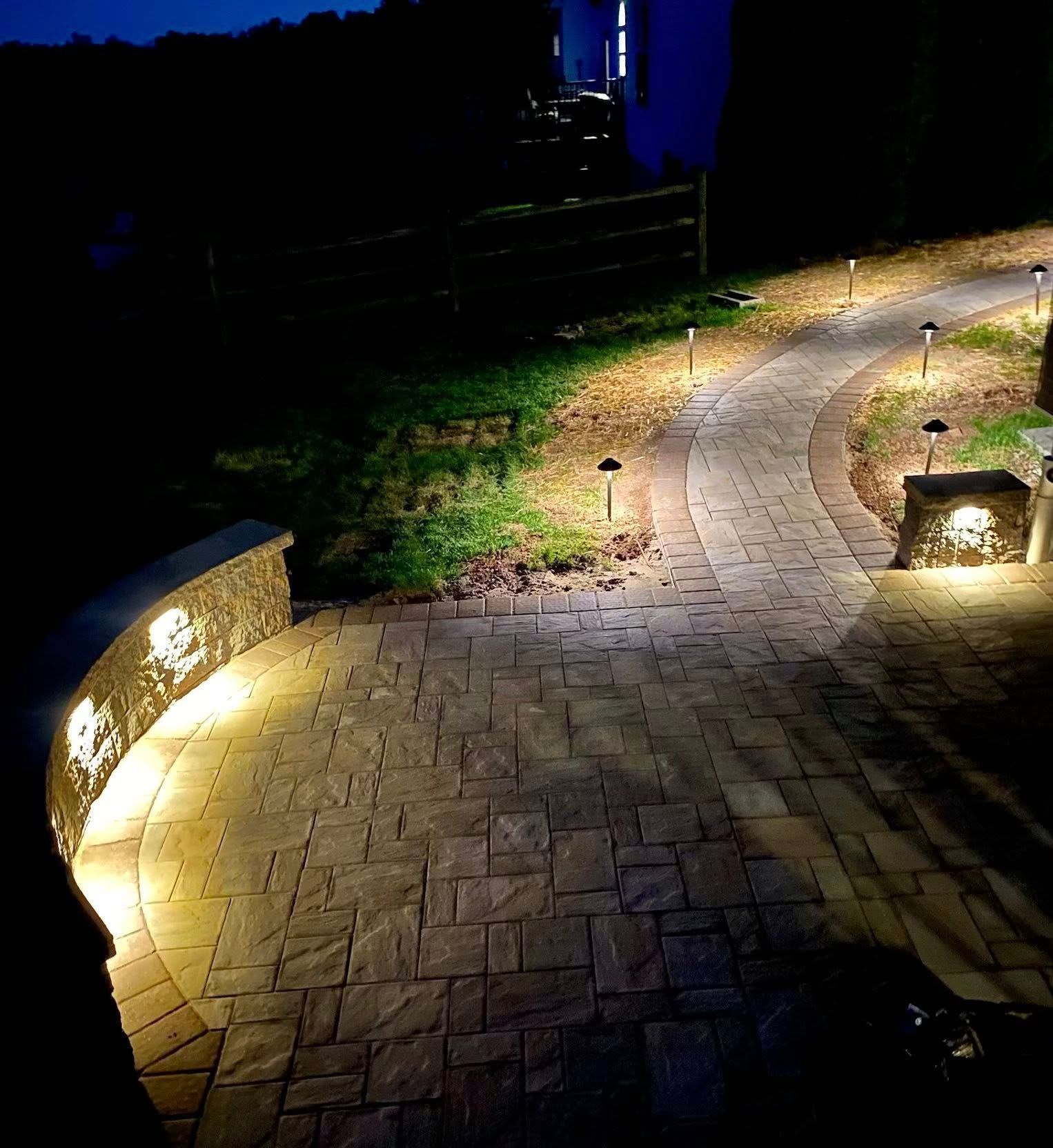 Stone pathway illuminated by outdoor lighting at night.