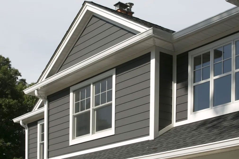 Dark gray house siding with white trim and windows.