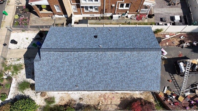 Overhead view of a house with a newly installed blue asphalt shingle roof.