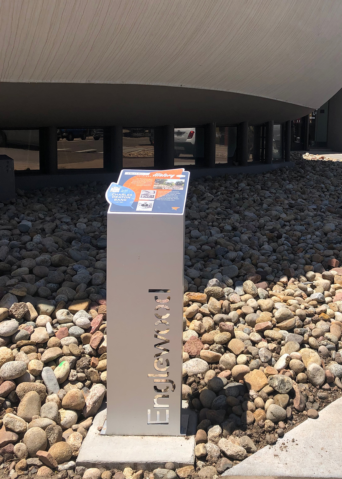 A sign that says enchanted is sitting in a pile of rocks