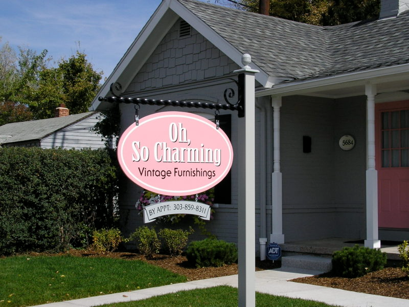 A pink sign that says oh so charming vintage furnishings