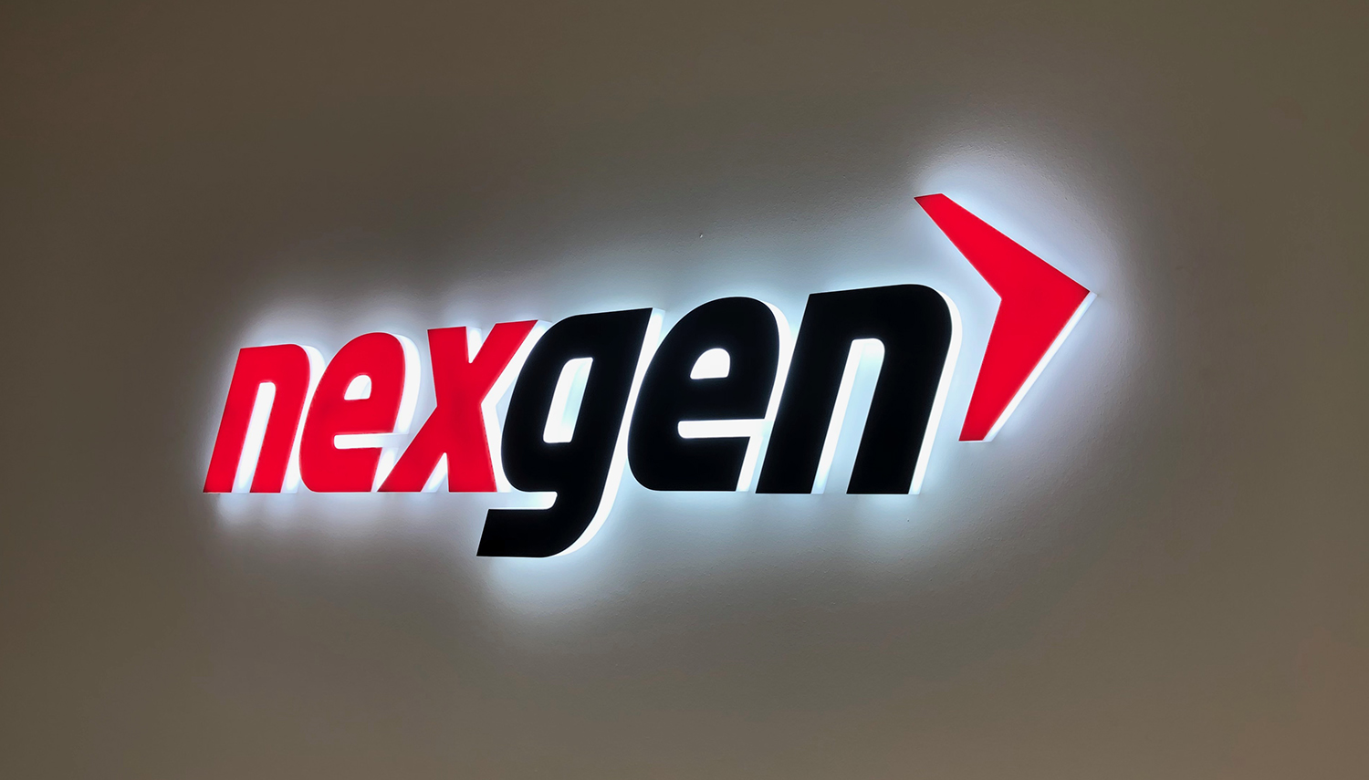 A nexgen logo is lit up on a wall