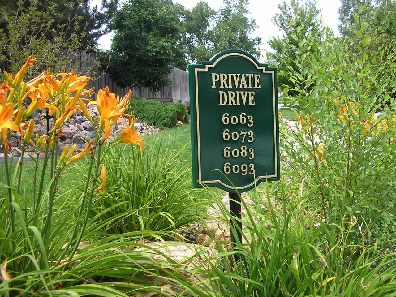 A green sign that says private drive on it