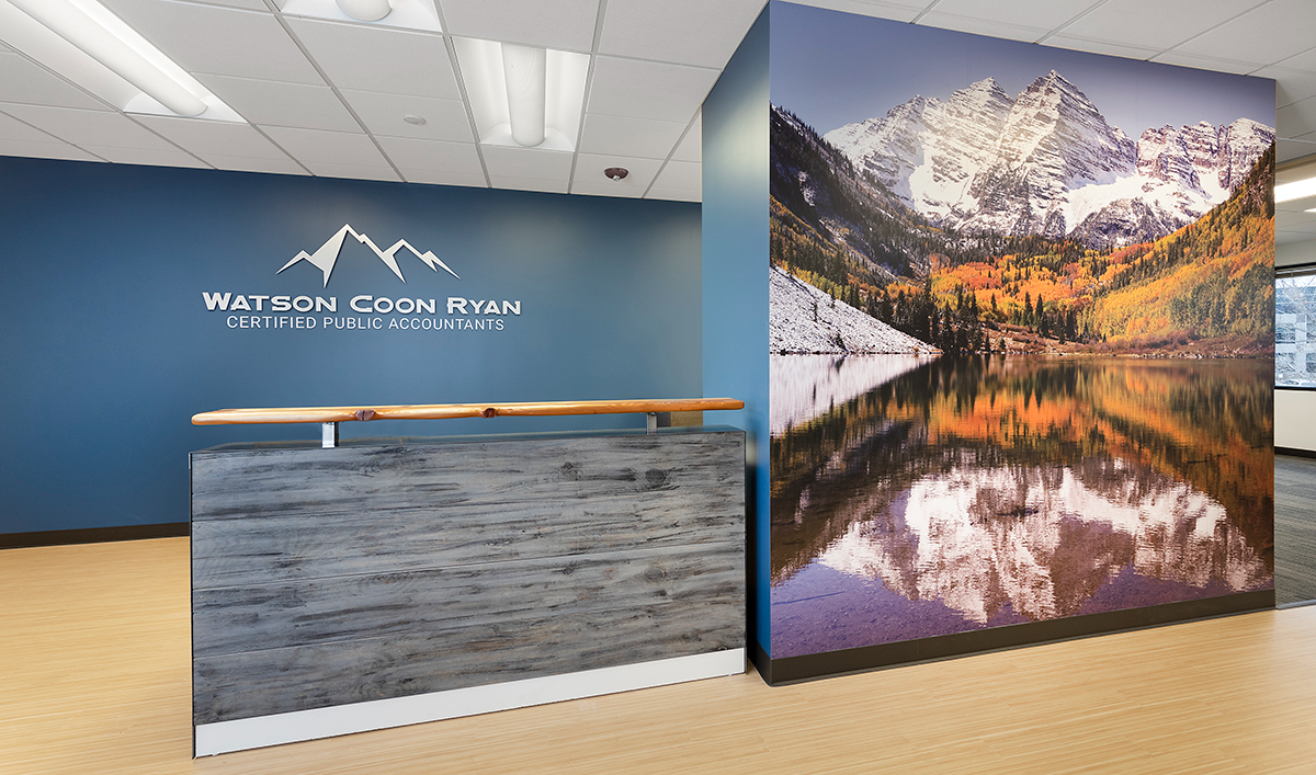 A reception area with a picture of mountains on the wall
