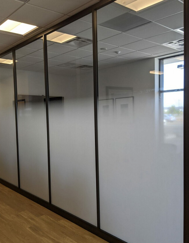A row of sliding glass doors with frosted glass in an office