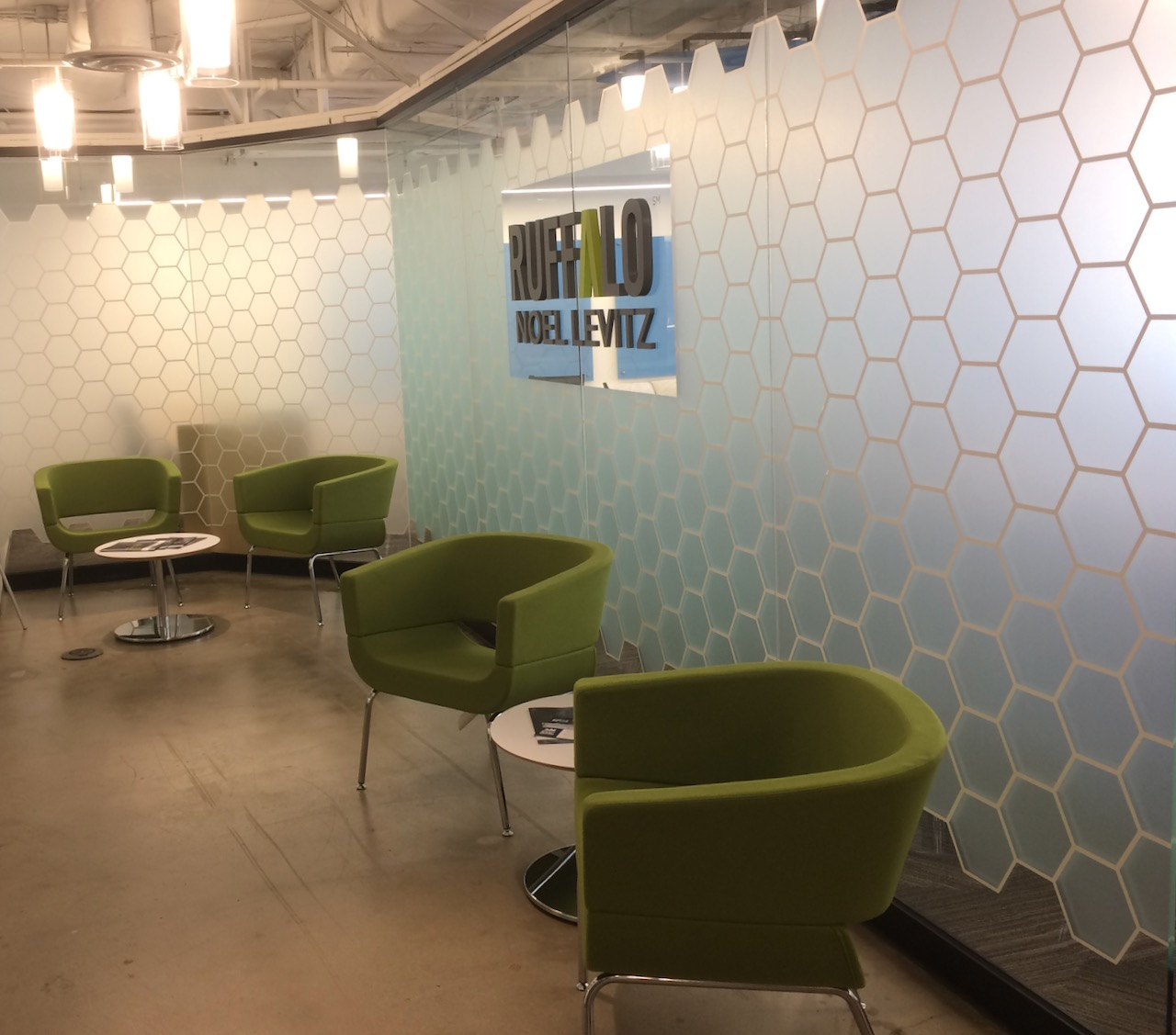 A waiting room with green chairs and a sign that says buffalo