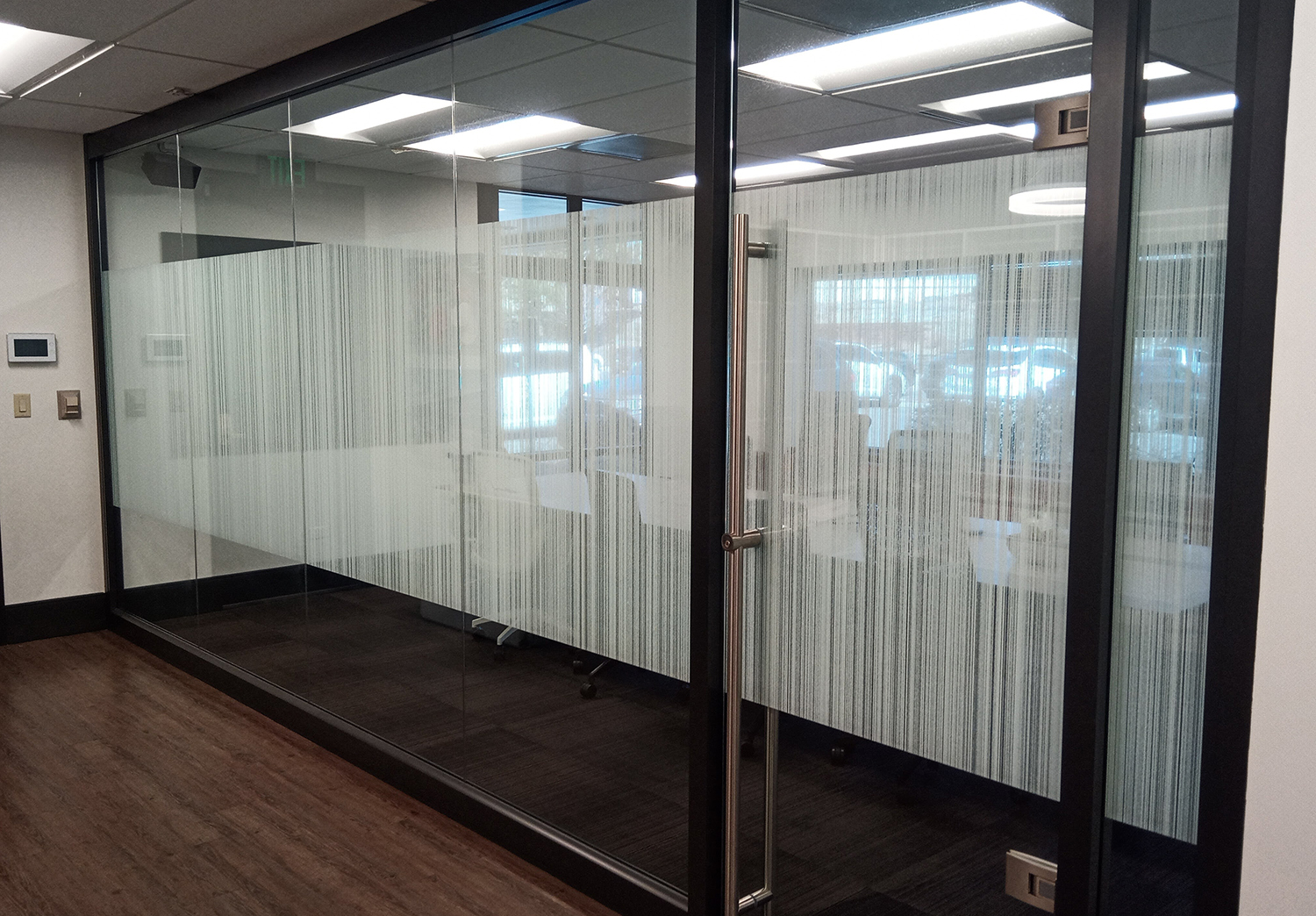 A room with a glass wall and a door with a striped design on it