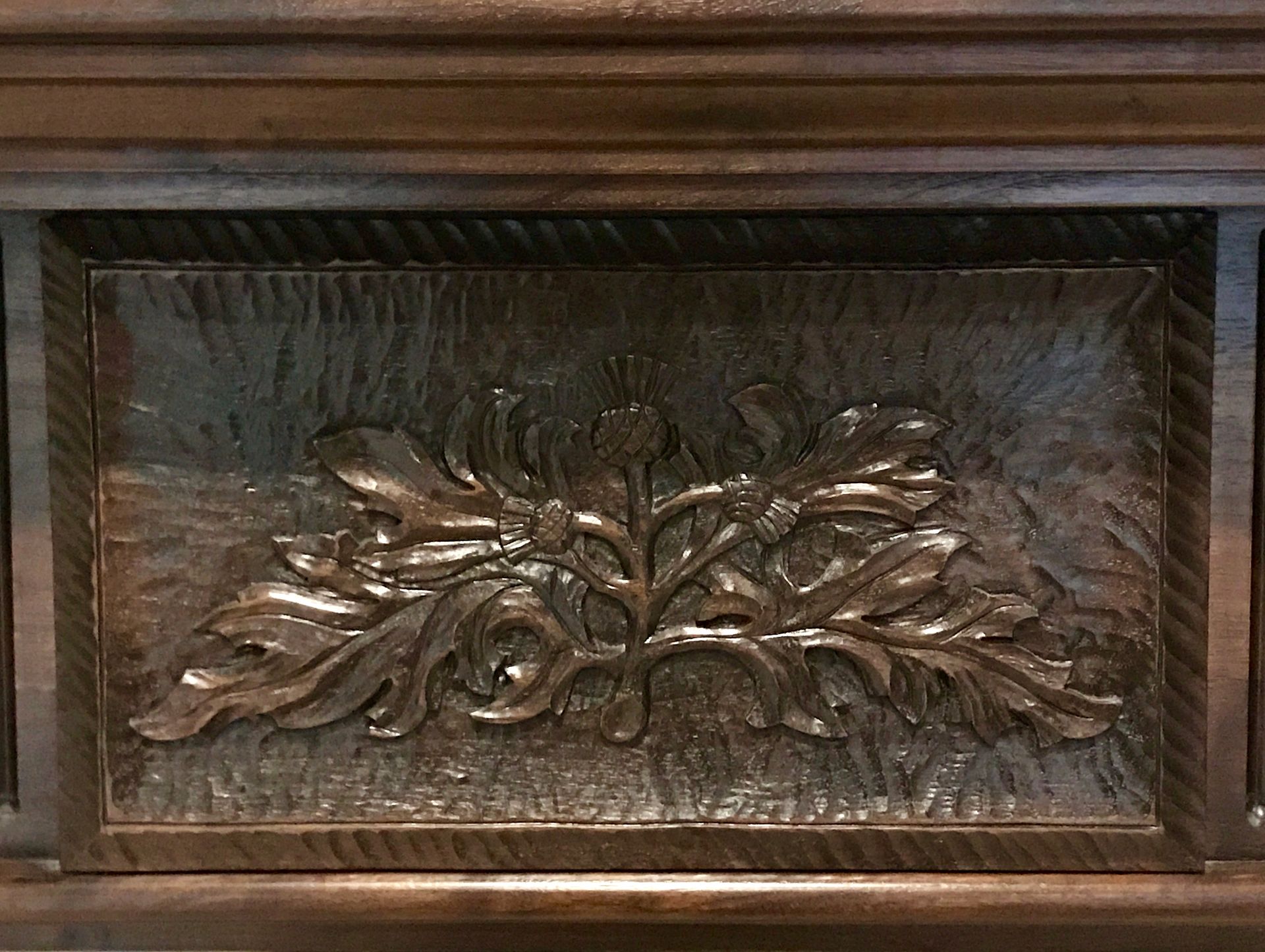 Wooden rectangular panel with carved leaves and floral design.