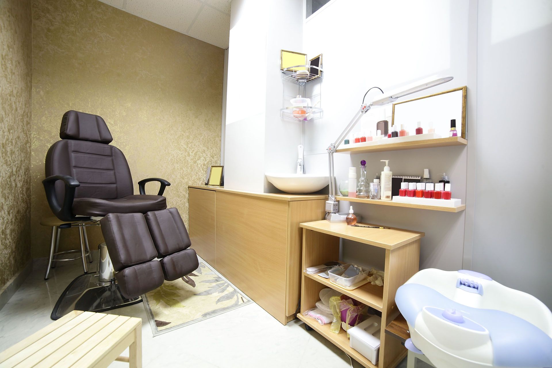 Dental treatment room with reclining chair, sink, cabinets, and instruments on a countertop