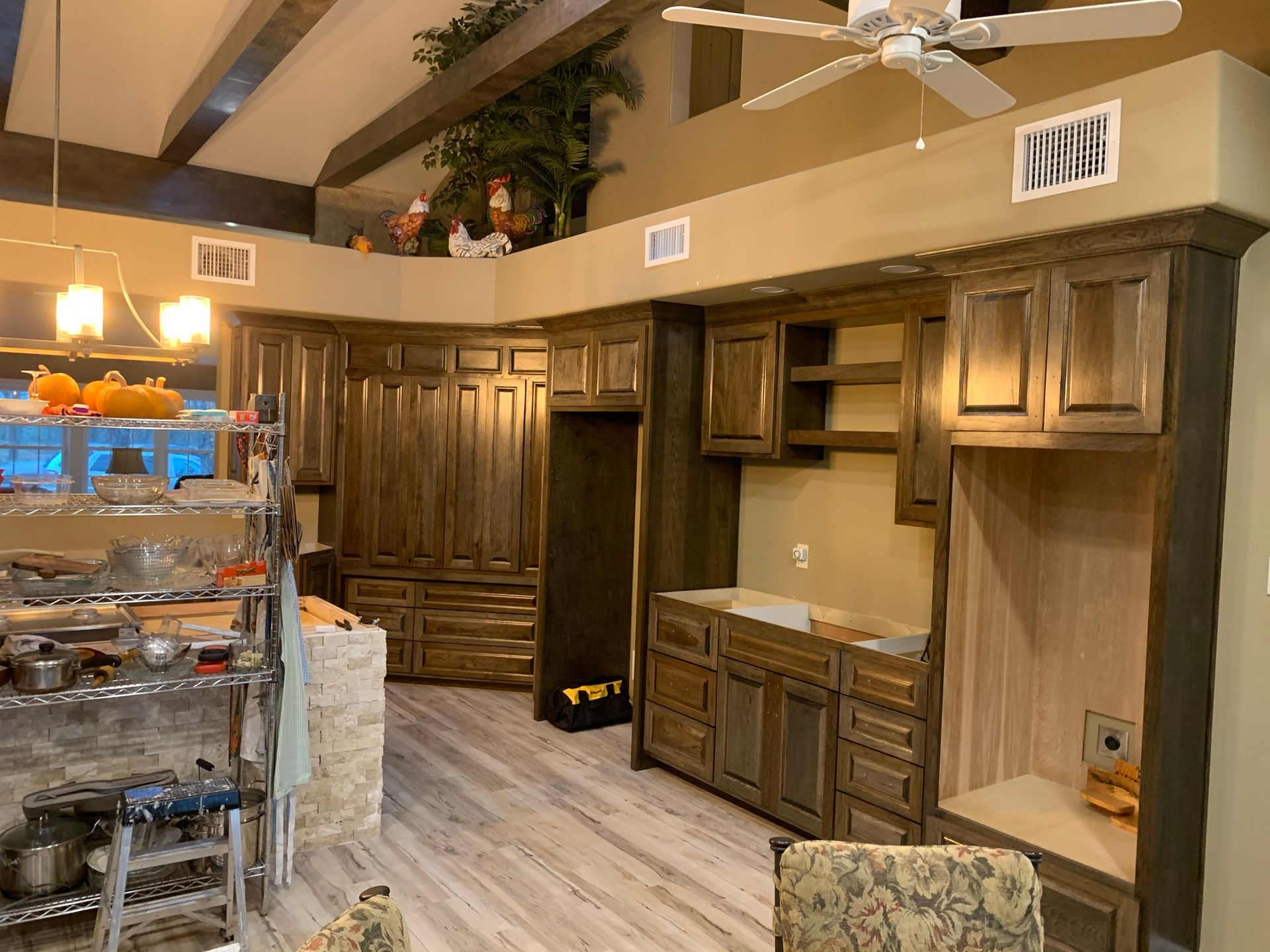 Kitchen with dark wood cabinets, light wood floor, and overhead lighting.