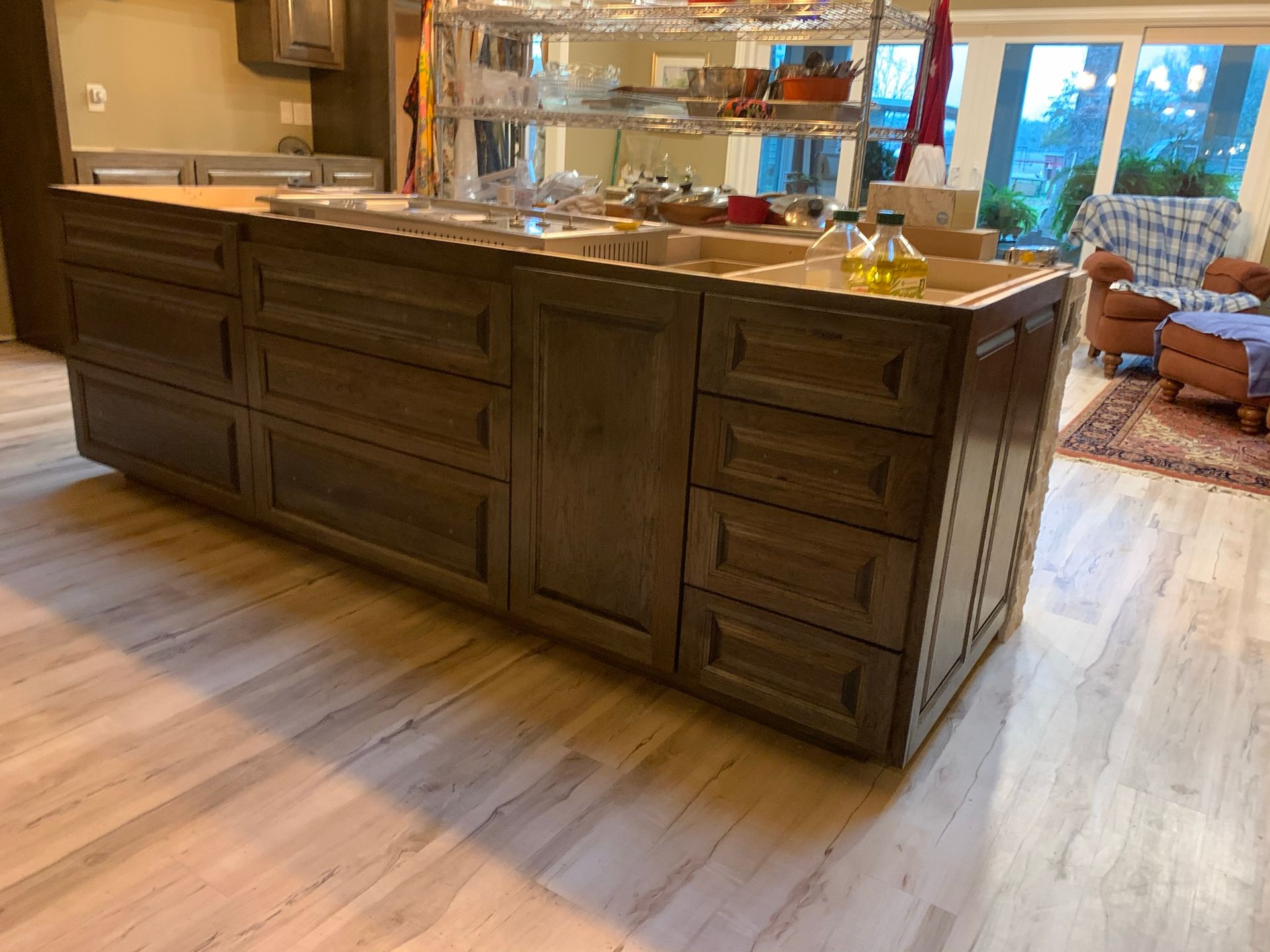 Kitchen island with drawers, cabinets, and a wooden countertop. Natural light from a nearby window.