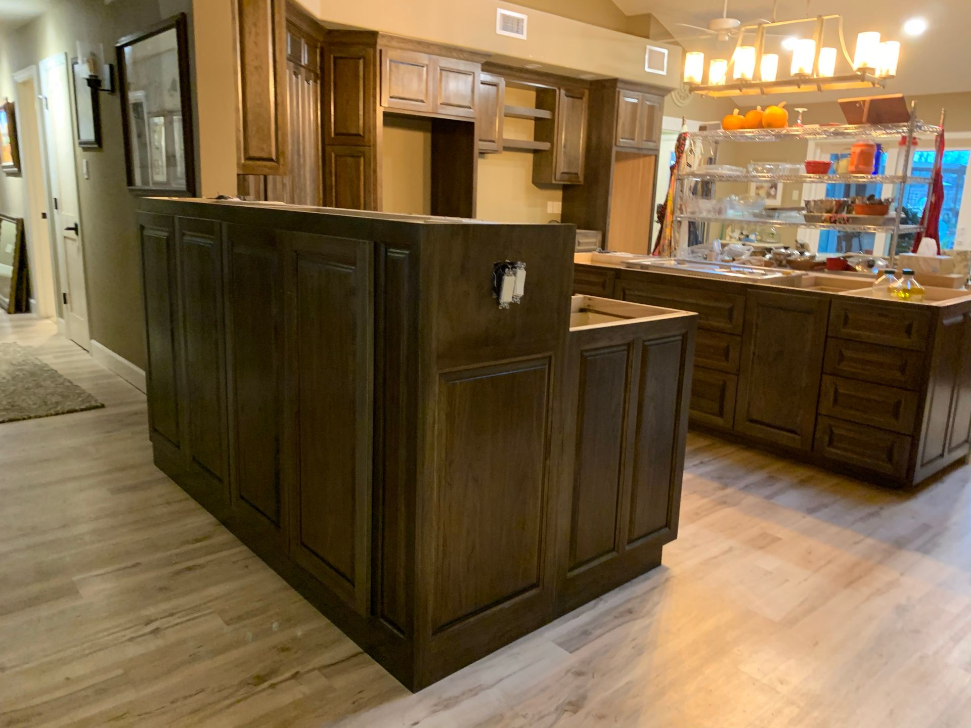 Dark wood kitchen cabinets and island on light wood floors.