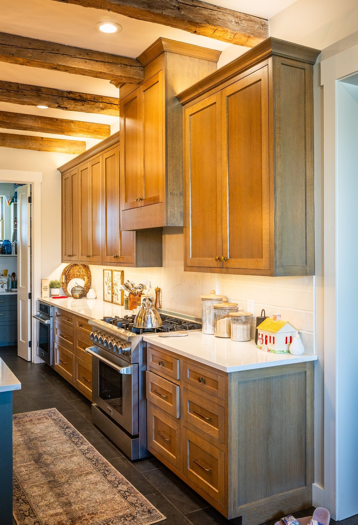Kitchen with wooden cabinets, stainless steel stove, and white countertops.
