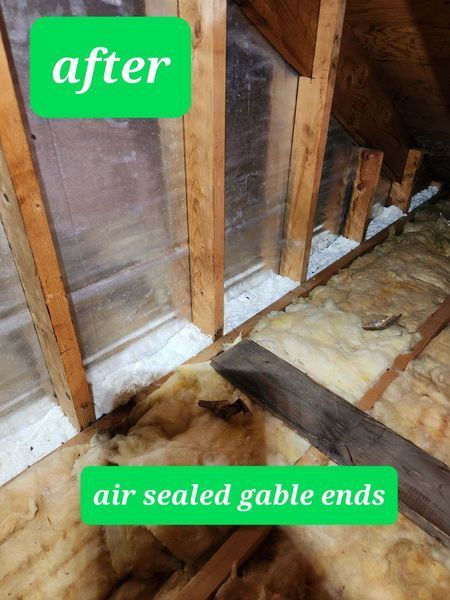 Air-sealed gable end in attic, showing insulation and plywood. Wooden beams and green text.