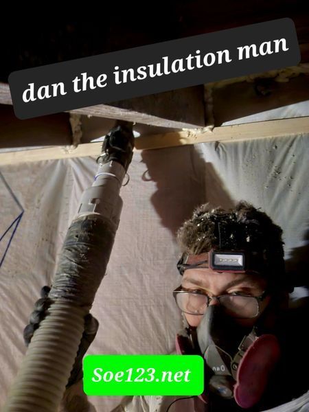 Man wearing safety gear blowing insulation into a ceiling. Soe123.net watermark.