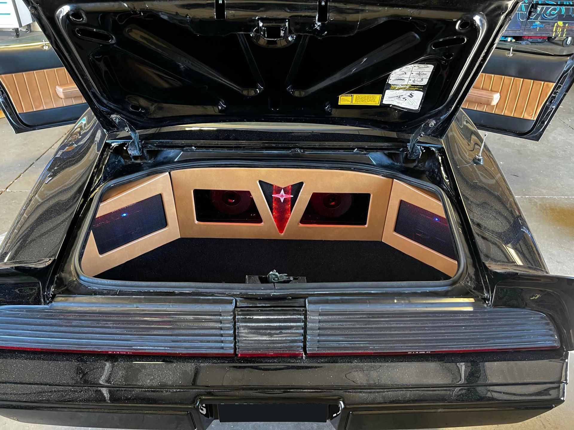 The back of a black car with the trunk open