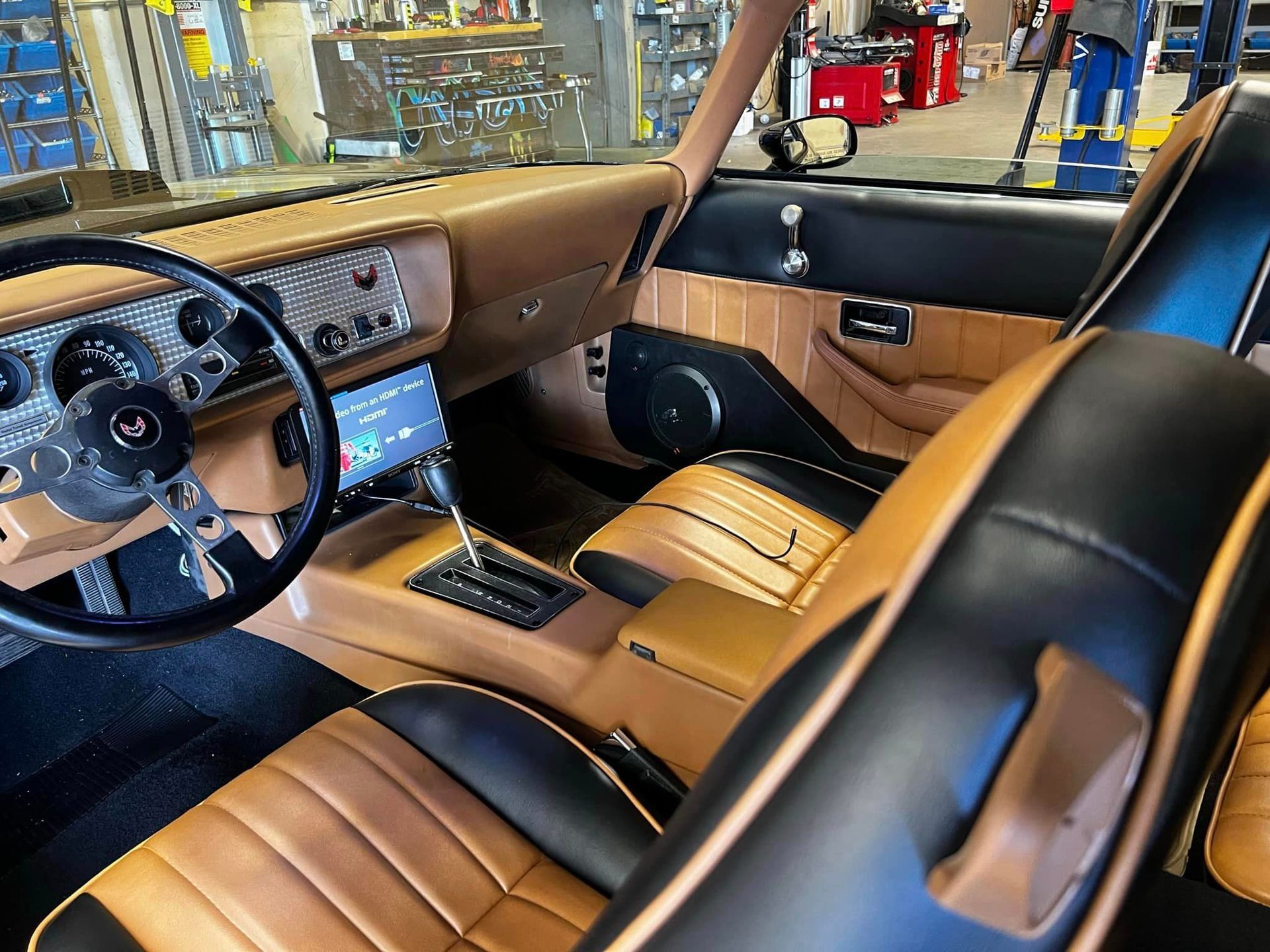 The interior of a car with brown and black seats and a steering wheel