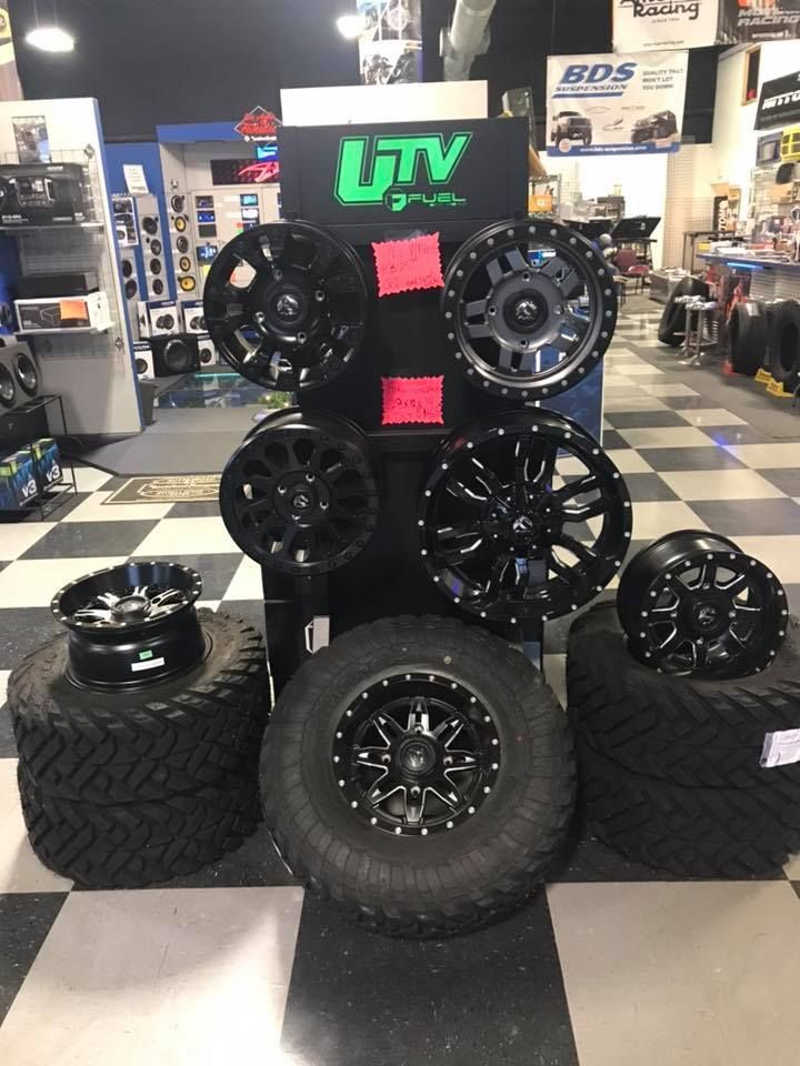 A display of tires and wheels in a store with a sign that says utv