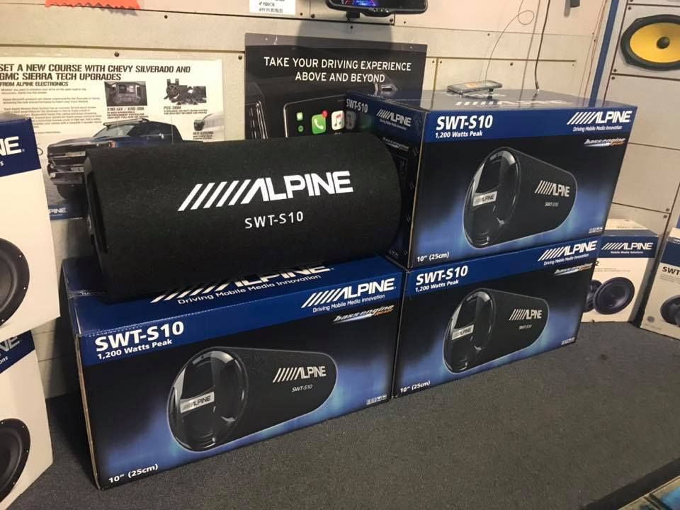 Alpine speakers are stacked on top of each other in a store.