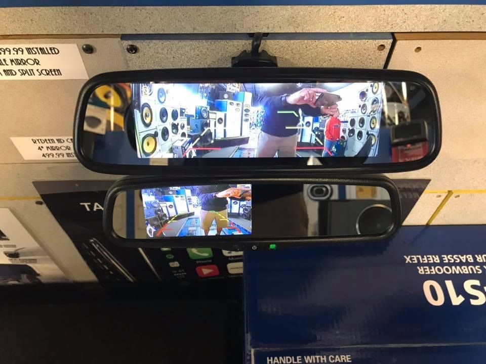 A rear view mirror with a monitor attached to it