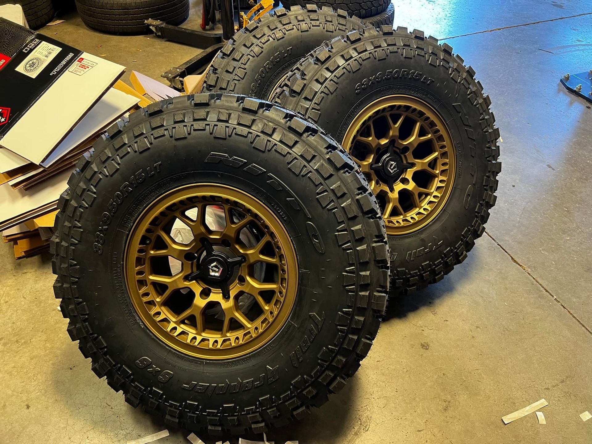 Two tires with gold rims are stacked on top of each other