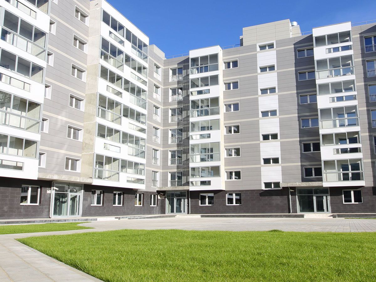 Exterior view of a condo building with a central grassy courtyard