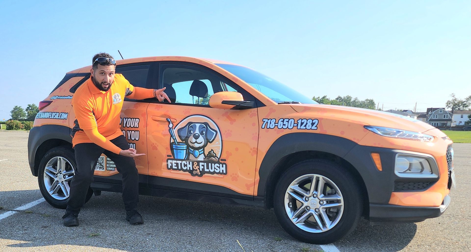 Man pointing at a car wrapped in orange advertising "Fetch & Flush" pet service.