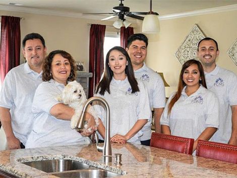 A group of people are posing for a picture in a kitchen.