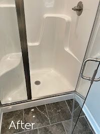 A bathroom with a shower stall and a tiled floor.