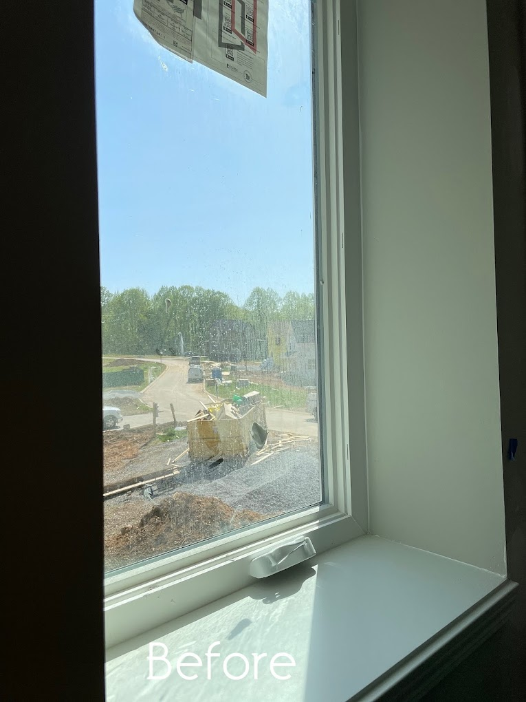 A before picture of a window with a view of a construction site.