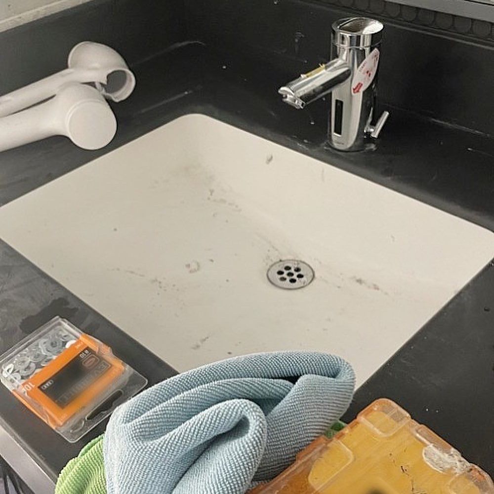 A bathroom sink with a faucet and a towel on the counter