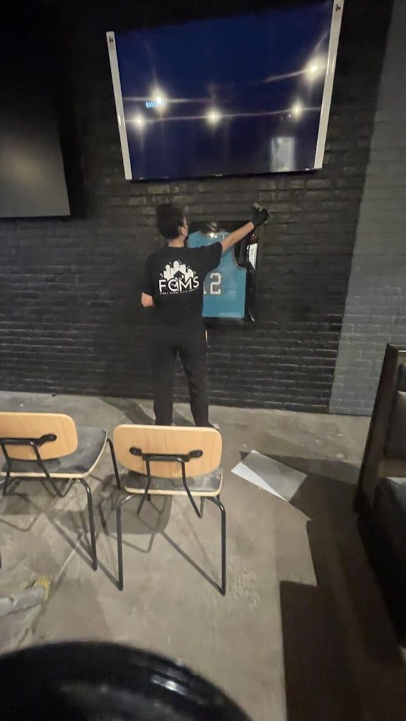 A man is hanging a jersey on a wall in a room.