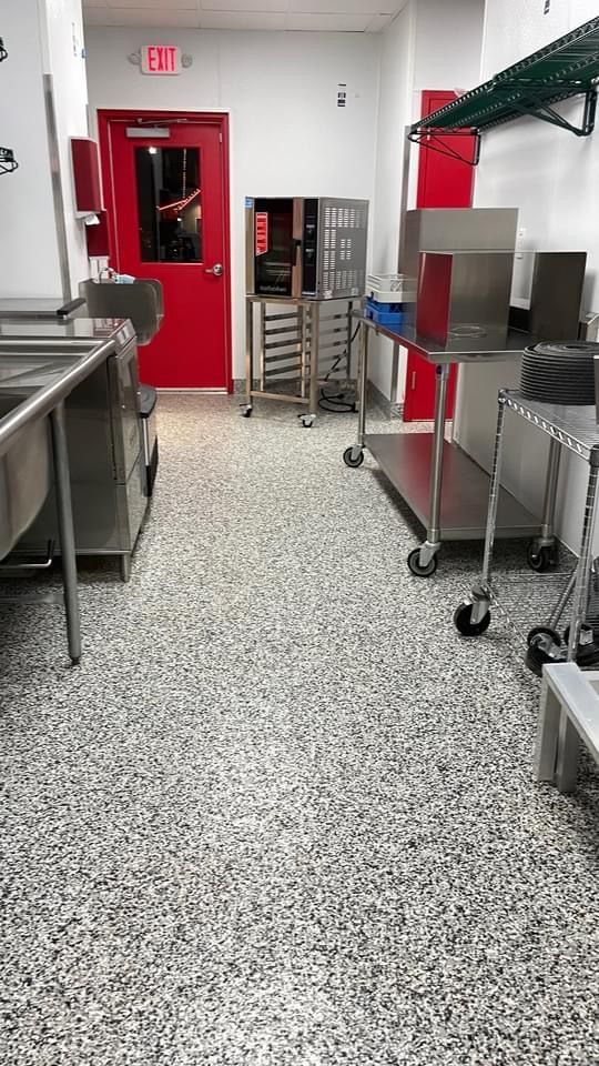 A kitchen with stainless steel appliances and a red door.