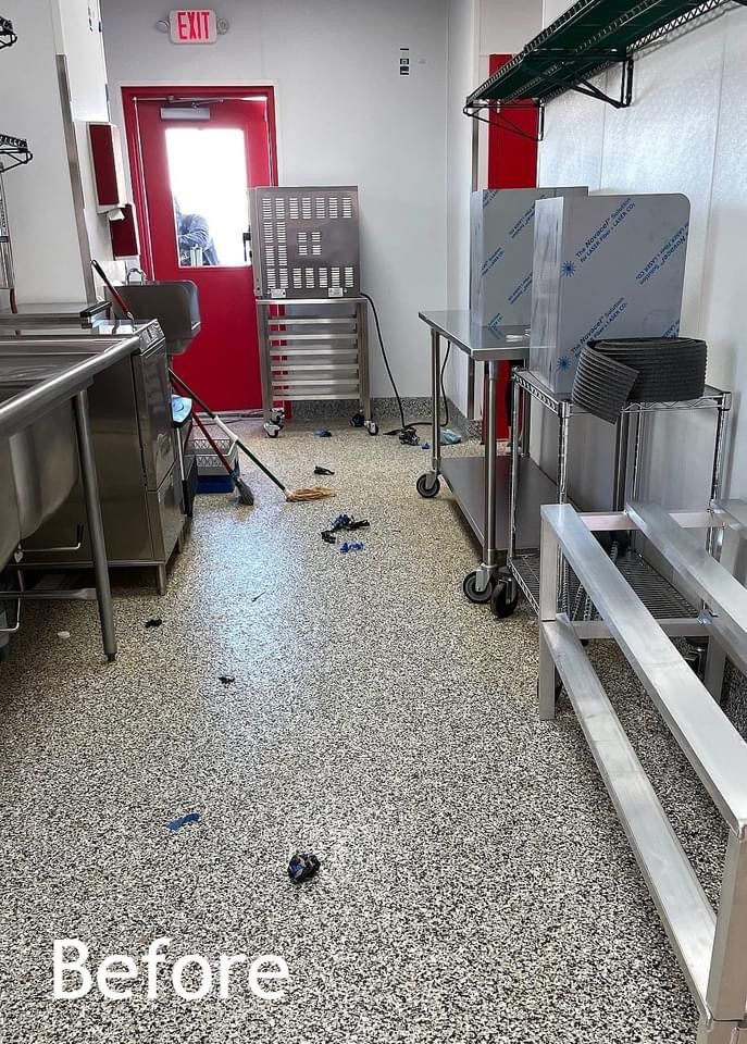 A before picture of a kitchen with stainless steel appliances and a dirty floor.