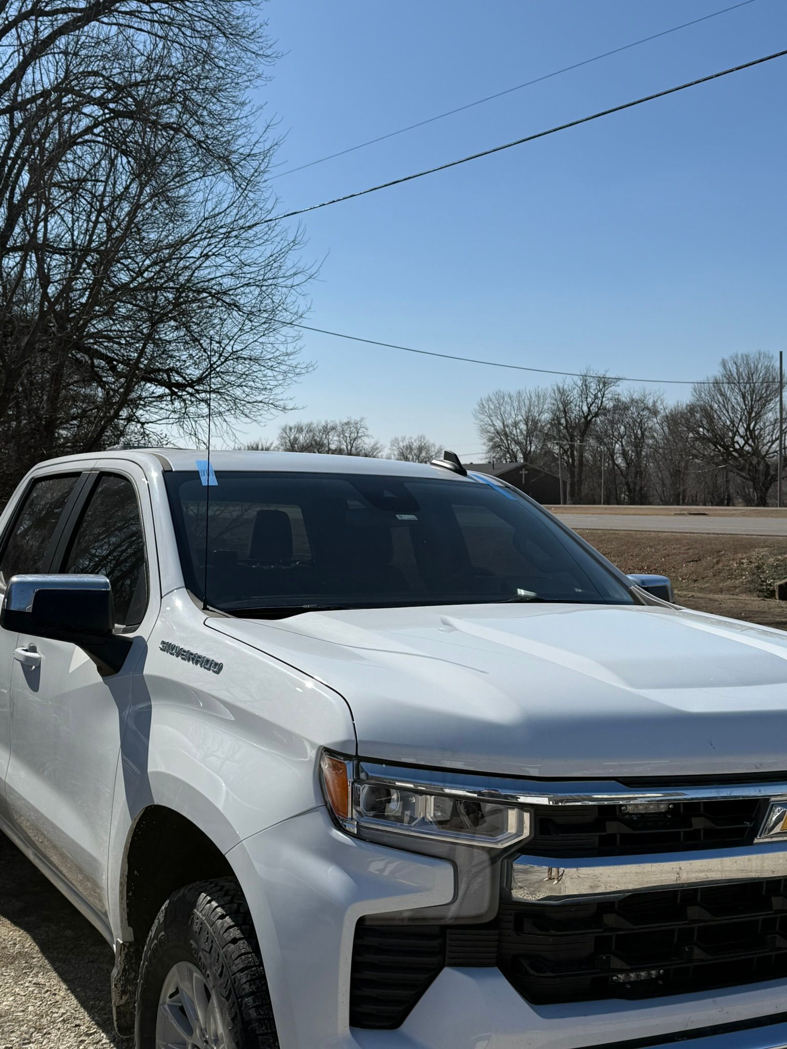 White Chevy Silverado pickup truck parked outside on a sunny day.