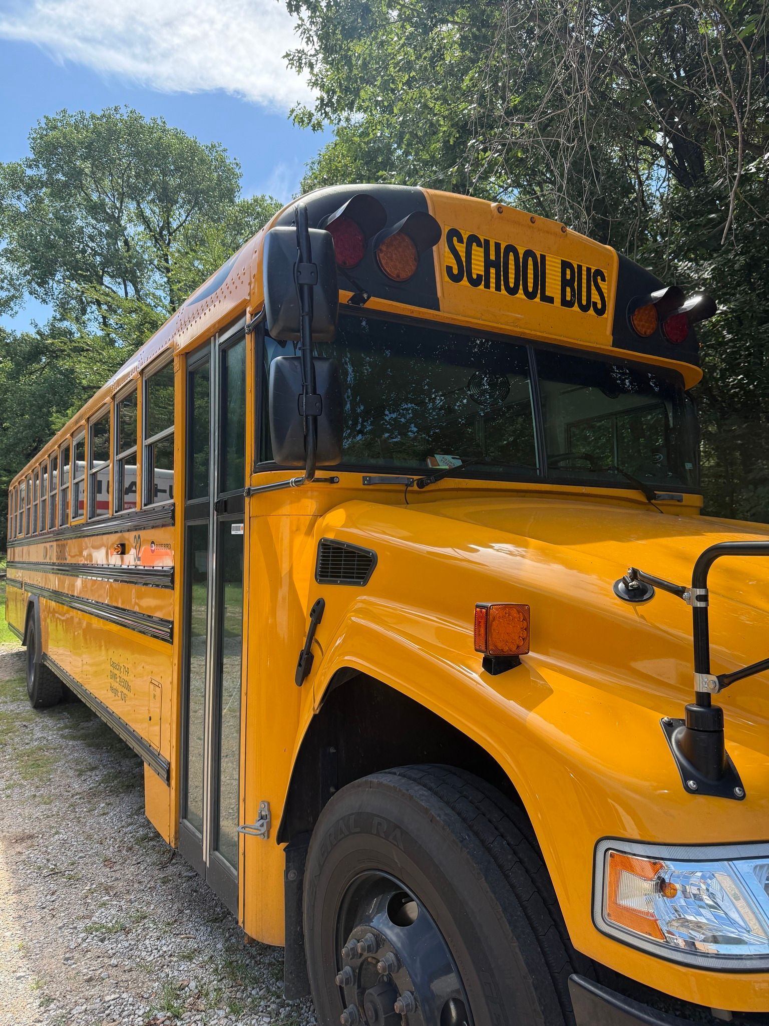 Yellow school bus parked outdoors on a sunny day. 